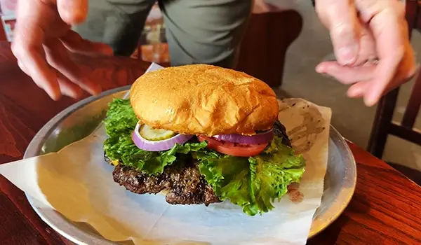 A delicious burger being served at a table.