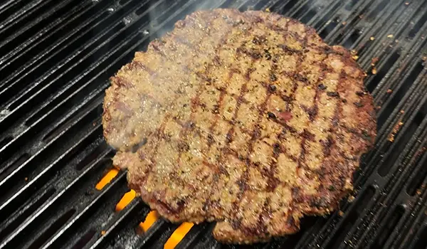 A deliciously seasoned and grilled burger ready for a homemade bun